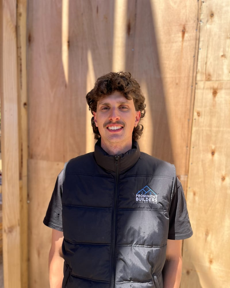 Andrew, apprentice carpenter at Prominent Builders, in a branded puffer vest on site