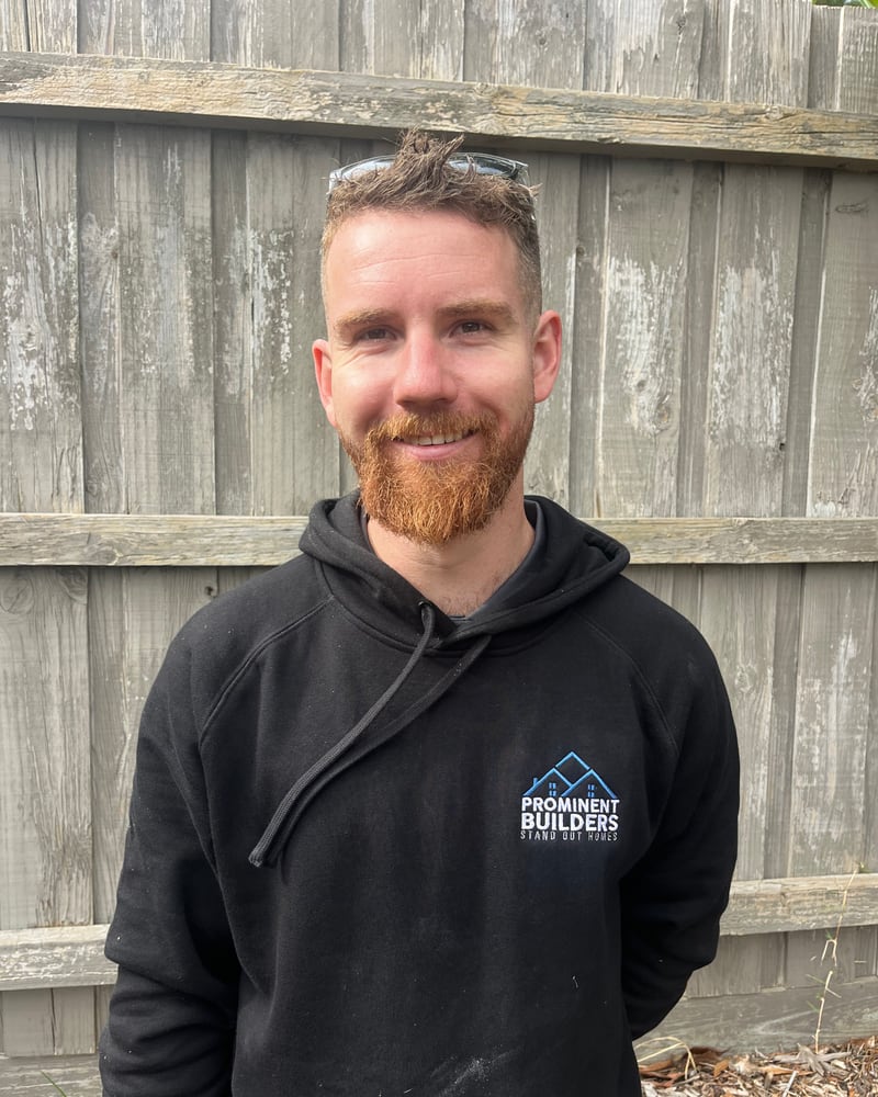 Cail, apprentice carpenter at Prominent Builders, in a branded hoodie with safety glasses pushed up on his head