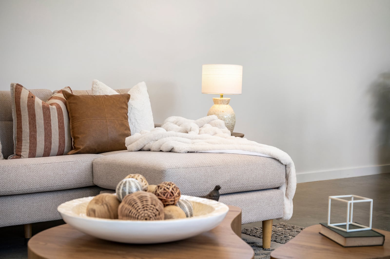Living room of a completed precast concrete home, with a linen sofa, styled coffee table and a plastered painted wall behind