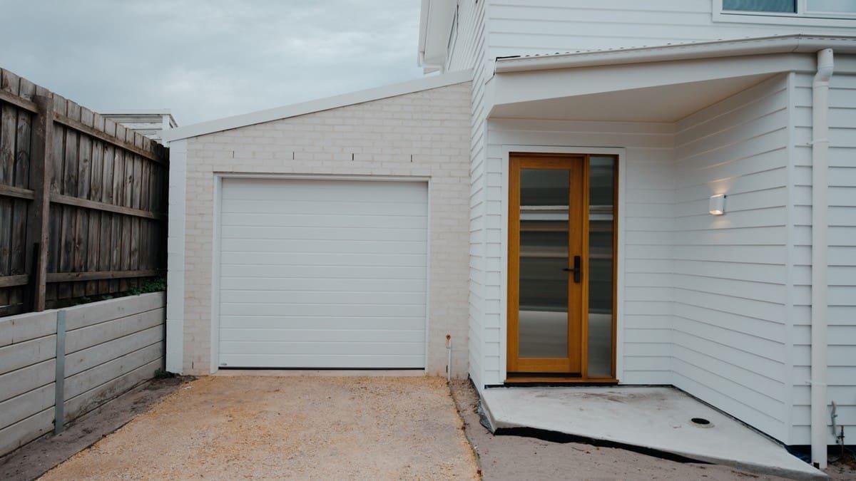 Completed weatherboard home extension with timber entry and garage